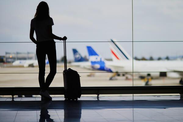 Mulher em aeroporto com bagagem de mão