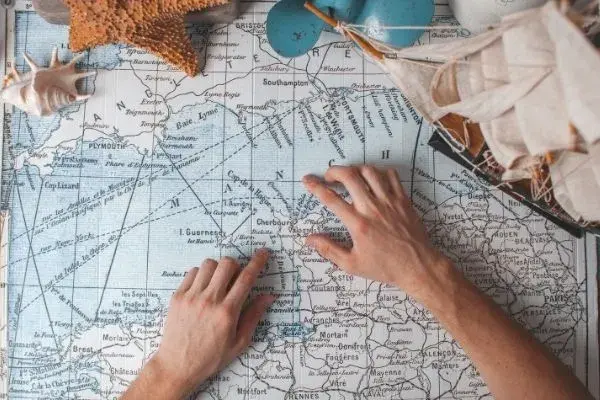 Mãos de uma pessoa em cima de um mapa