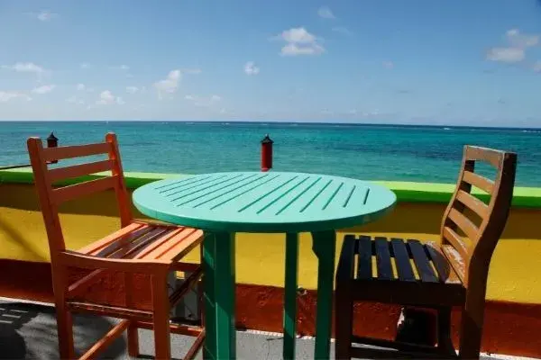 Mesa e cadeiras coloridas e paisagem do Caribe