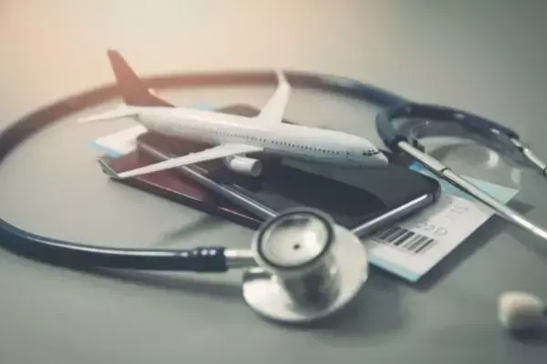 Documentos, avião em miniatura e estetoscópio indicando segurança em viagem