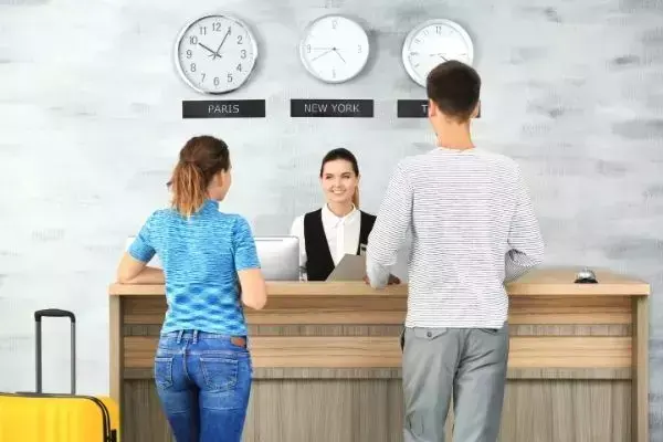 Casal sendo atendido em recepção de hotel