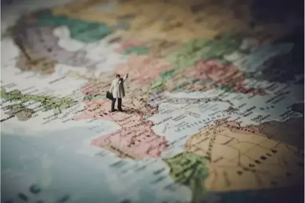 Viajante em miniatura em cima de mapa da Europa