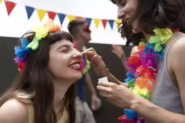 mulher passando maquiagem de carnaval em amiga