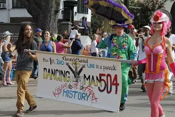 Pessoas fantasiadas segurando faixa no Mardi Gras, em Nova Orleans