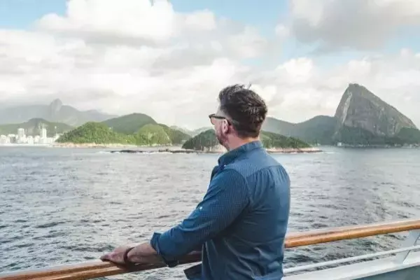 homem olhando a vista do pão de açúcar de um barco