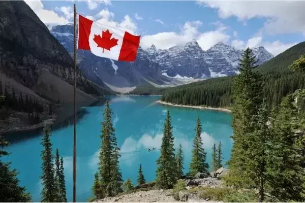 Paisagem de lago no Canadá, com bandeira do país e montanhas