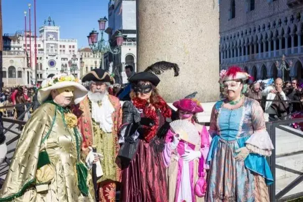 Pessoas vestidas com roupas e máscaras tradicionais do carnaval de Veneza