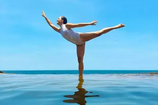 Imagem de Nai em postura de bailarina no mar