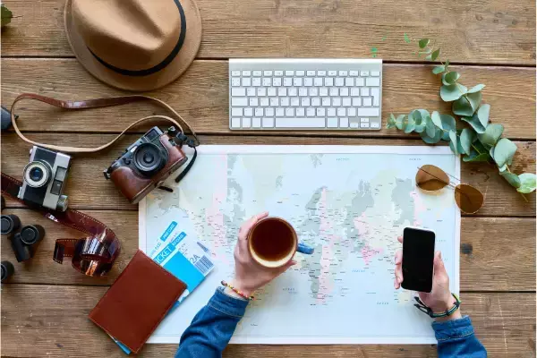 Mapa, caneca, celular, passagens, câmera fotográfica e outros itens de viagem