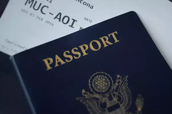 Foto de um passaporte em cima de uma passagem impressa de avião.