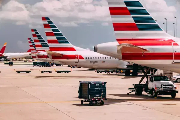 Foto de alguns aviões da American Airlines, cada um com uma pintura da bandeira dos Estados Unidos.