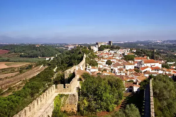 Foto mostrando as muralhas e as casinhas brancas de Óbidos ao fundo.
