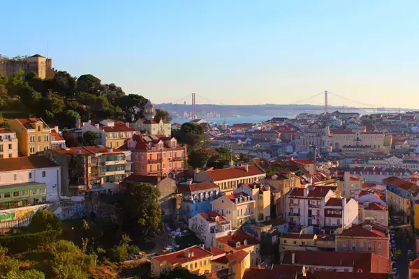 Foto da paisagem de Lisboa, mostrando vários edifícios e a Ponte 25 de Abril no fundo.