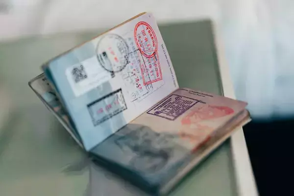 Foto de um passaporte aberto em cima da mesa.