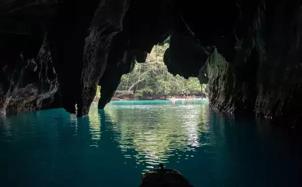 Imagem de uma caverna dentro de um mar azul límpido.