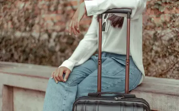 Uma mulher sentada perto de suas malas.