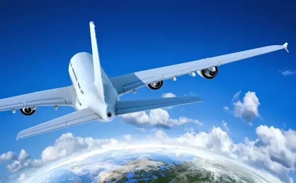 Um avião sobrevoando o planeta com algumas nuvens ao redor.