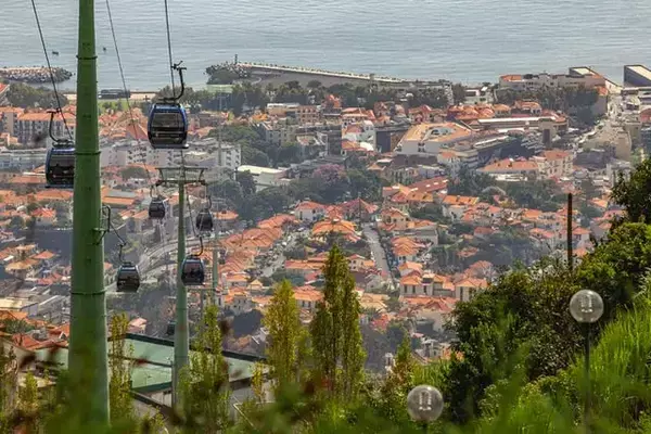 Cidade de Funchal, em Portugal, com bondinhos, casas e praia ao fundo