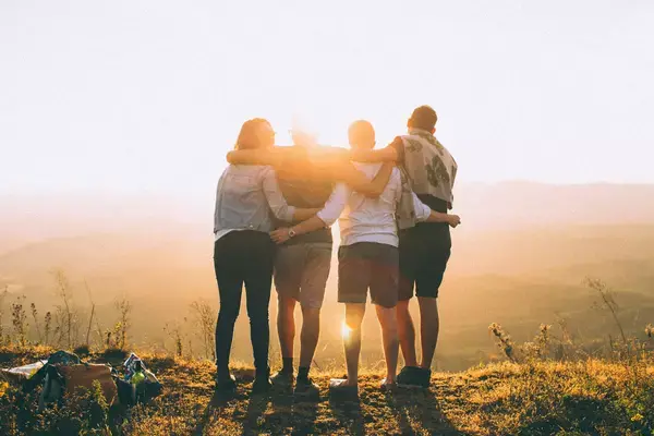 Família abraçada em montanha durante o pôr do sol