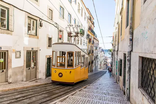 Bondinho amarelo subindo uma ladeira me Lisboa, Portugal