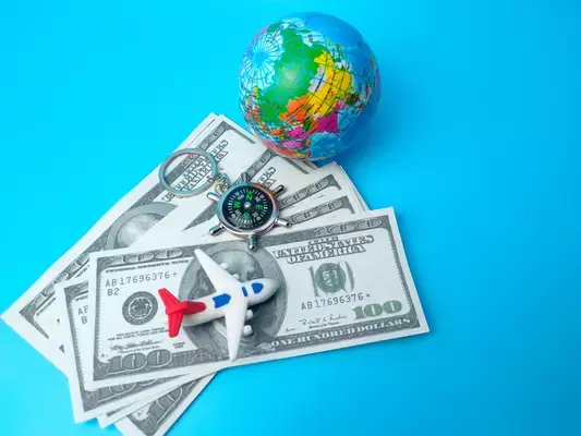 Notas de dinheiro, miniatura de avião e de globo terrestre