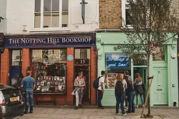 Pessoas caminhando na rua, próximas à Nothing Hill Bookshop.