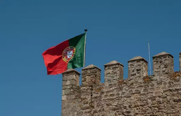 Bandeira de Portugal fincada no topo de um muro.