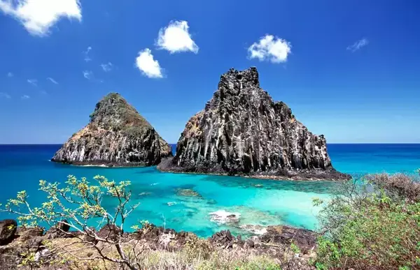Duas rochas no meio do mar azul cristalino.