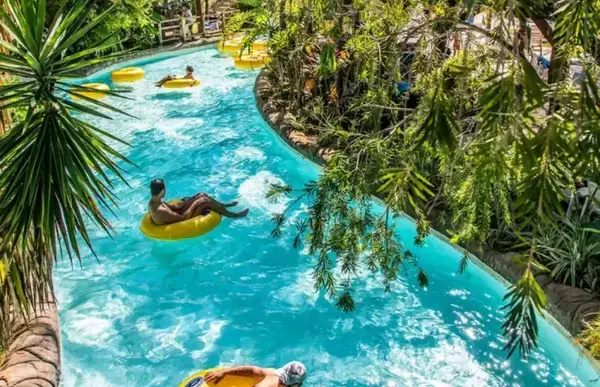 Um rio quente, com dois turistas em bóias amarelas percorrendo o trajeto da correntesa.