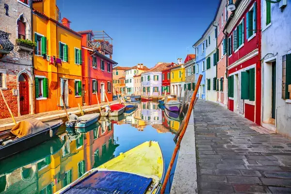 Prédios coloridas, rio e barcos em Veneza