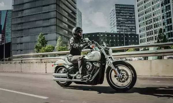 Motociclista em avenida entre prédios