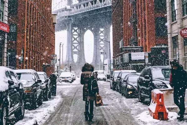 Mulher caminhando em rua com neve em Nova York