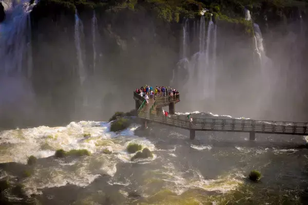 Vista aérea das Cataratas do Iguaçu e plataforma onde turistas observam as quedas d'água