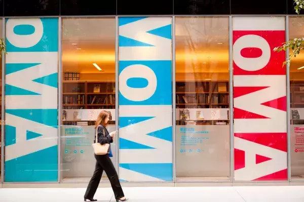 Mulher caminhando próxima ao Museu de Arte Moderna em NYC
