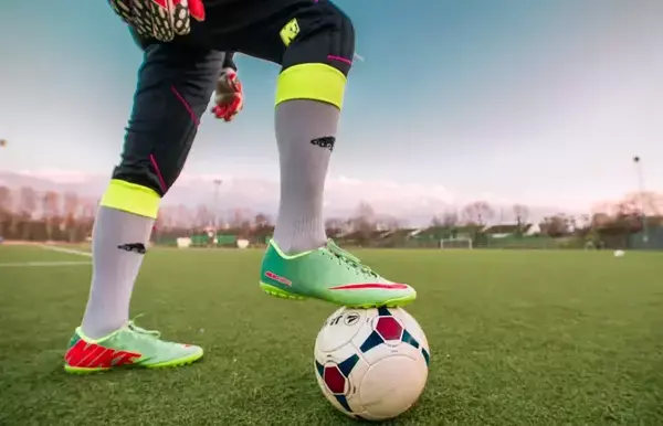 Um jogador de futebol da Libertadores apoiando o pé na bola.