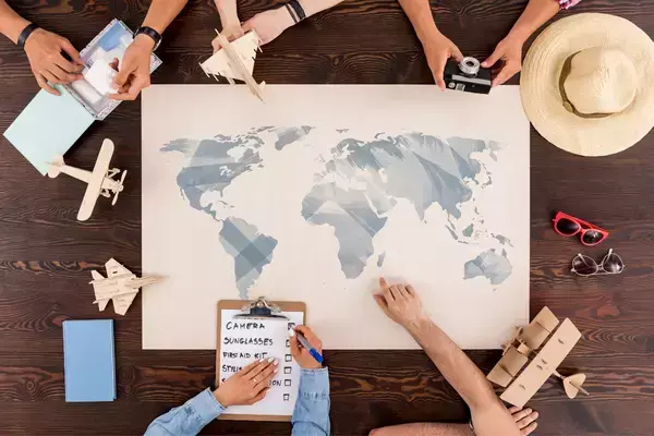 grupo de viajantes planejando viagem com mapa, documentos e outros itens