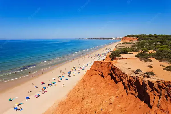imagem sobre a praia da falésia, em Algarve - PT, com mar azul e visitantes na faixa de areia