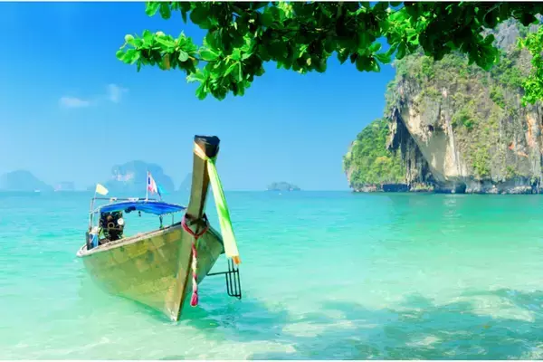 Praia de Krabi, na Tailândia, com mar e barco na areia