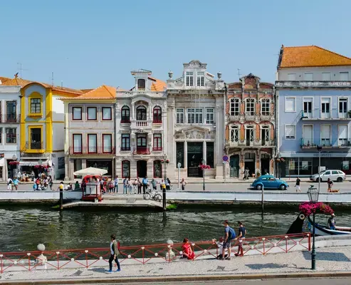 Pessoas próximas a água em frente a prédios em Aveiro, Portugal