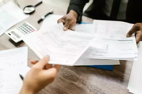 Uma pessoa entregando documentos a outra
