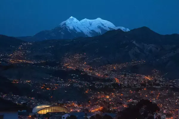 Vista de montanha com neve e luzes da cidade durante a noite em La paz, capital da Bolívia