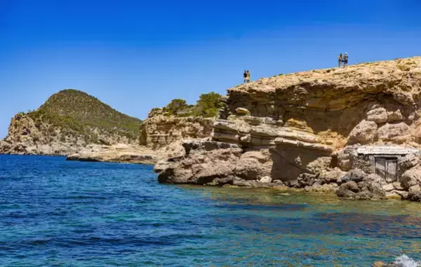 um mar límpido com uma rocha no canto