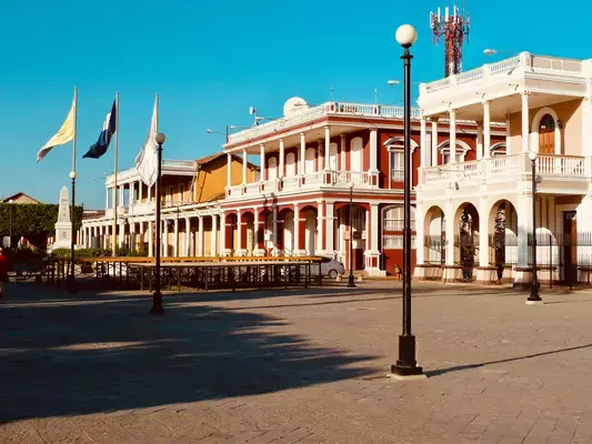 Praça com construções antigas e bandeiras em Granada, Nicarágua