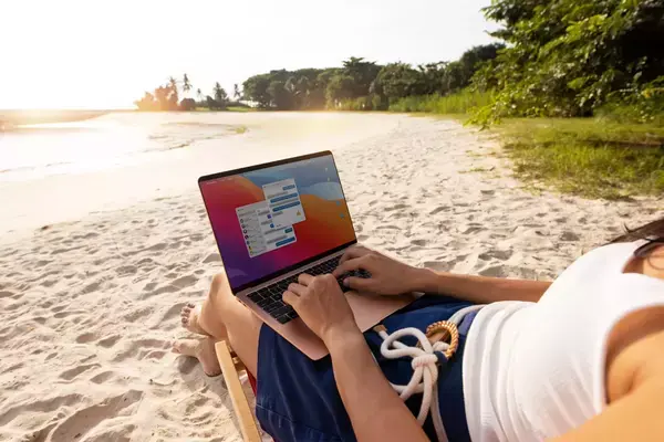 Nômade digital trabalhando com notebook na praia