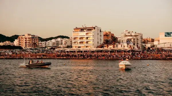 barcos no mar de Ibiza e na ponta uma galera reunida