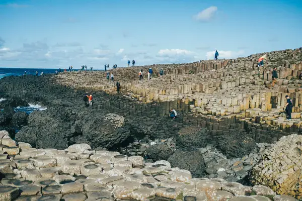 Turistas na gigante calçada rochosa Irlanda
