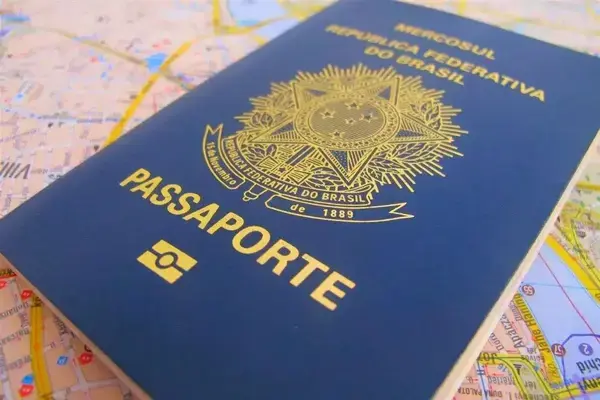 Passaporte brasileiro fechado em cima de mapa