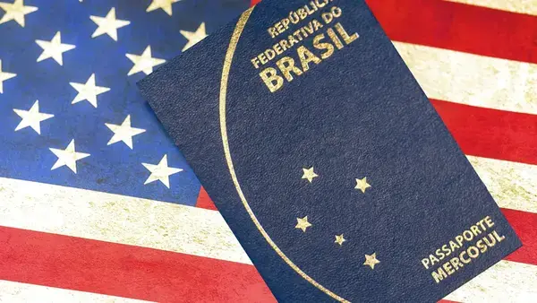 Passaporte brasileiro sobre bandeira dos Estados Unidos