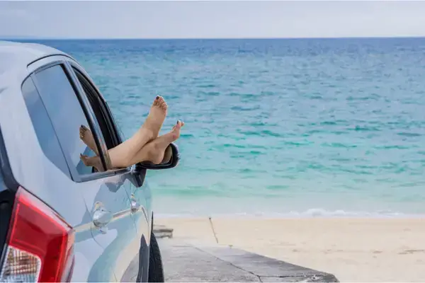 Turista relaxando dentro de carro estacionado perto de praia