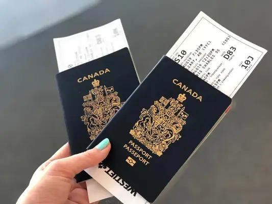 pessoa segurando dois passaportes canadenses com passagens aéreas